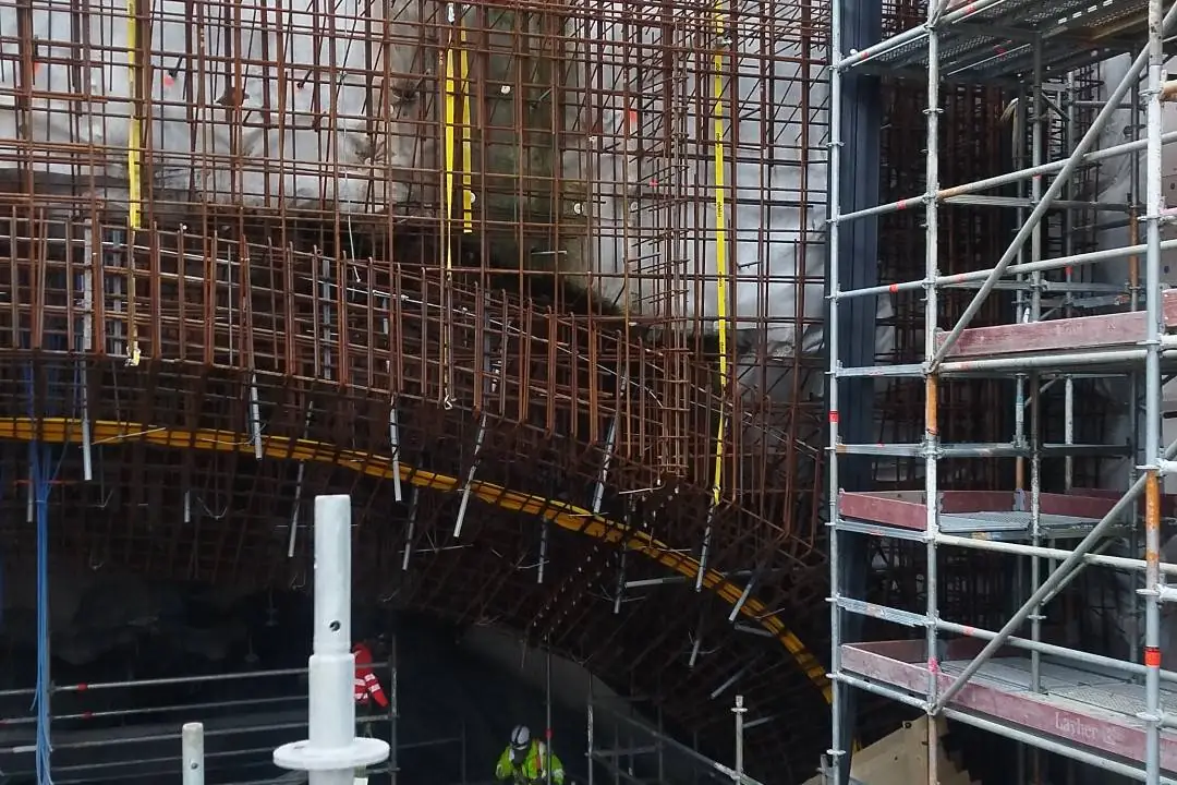 Armering för ett välvt betongtak, med ställning och arbetare under valvet